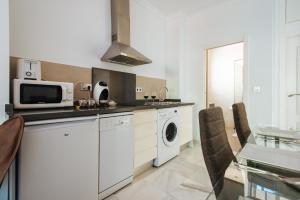 a kitchen with a microwave and a washer and dryer at Hostly Plaza de Armas Lightfull loft-Center-Parking op-CLess in Seville
