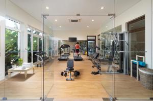 a woman walking through a gym with treadmills and machines at Monte Santo Resort in Carvoeiro