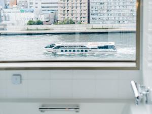 een boot op het water door een raam bij The Share Hotels Lyuro Tokyo Kiyosumi in Tokyo