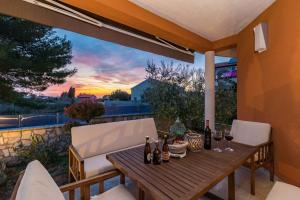 un tavolo in legno con bottiglie di vino su un patio di Villa Veronica with great sea view & private pool - calm & relax holidays in Istria a Peroj