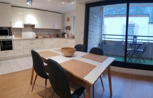 cocina con mesa y sillas y cocina con ventana en Grand T3 Neuf Résidence Centre Proche Gare Vannes, en Vannes