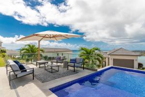 une terrasse avec un parasol et une piscine dans l'établissement Rose Quartz Condo Suite Grenada, à Egmont