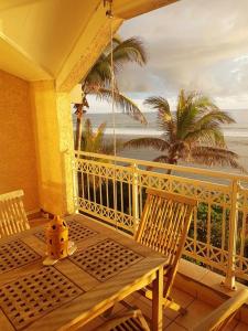 um alpendre com uma mesa e cadeiras e o oceano em Appartement d'une chambre avec vue sur la mer balcon amenage et wifi a Les Trois Bassins a 1 km de la plage em Le Bois de Nèfles