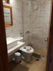 een badkamer met een wit toilet en een wastafel bij Rappos Studios in Kallithea