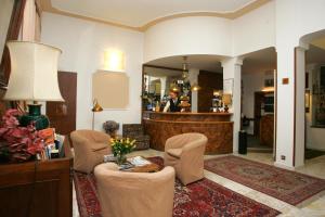 ein Wohnzimmer mit Stühlen, einem Tisch und einem Spiegel in der Unterkunft Hotel Eden in Turin