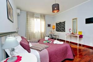 um quarto com uma cama grande e um cobertor rosa em Alloggio Re Di Roma em Roma