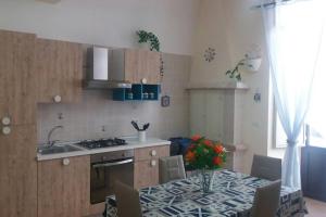 a kitchen with a table and a sink and a stove at Onda Mare in Giovinazzo