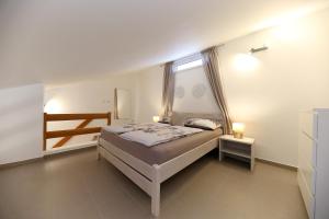 ein kleines Schlafzimmer mit einem Bett und einem Fenster in der Unterkunft Apartmani Branka Murter in Murter