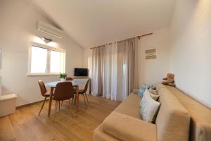 ein Wohnzimmer mit einer Couch und einem Tisch in der Unterkunft Apartmani Branka Murter in Murter