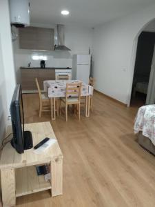 Una cocina y un comedor con una mesa y un televisor. en Can Fabul, en Sant Carles de la Ràpita