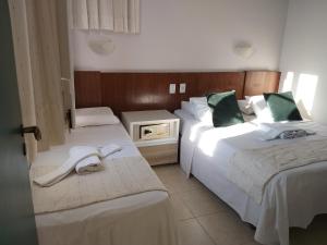 a hotel room with two beds with towels on them at Hotel Pousada da Mangueira in Salvador