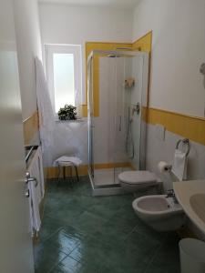 Hotel Terme Alexander في ايسكيا: حمام مع دورتين مياه ودش ومغسلة