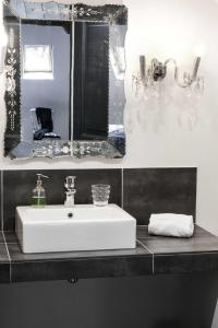 La salle de bains est pourvue d'un lavabo blanc et d'un miroir. dans l'établissement Au Velocipede, à Saint-Valery-sur-Somme
