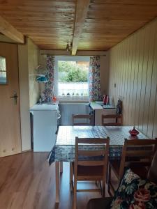 Una cocina y un comedor con mesa y sillas. en Siedlisko Bieszczadzkie 2, en Lutowiska 6 fotos más