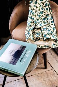 a book sitting on a chair next to a chair at Au Velocipede in Saint-Valery-sur-Somme