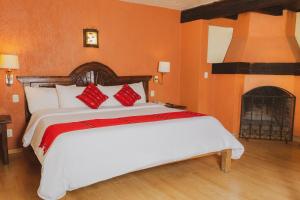 1 dormitorio con 1 cama blanca grande con almohadas rojas en Plaza Magnolias en San Cristóbal de Las Casas