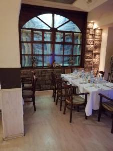 comedor con mesa, sillas y ventana en Хотел-Ресторант Тиролиа, en Gorna Oryakhovitsa