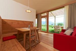 a living room with a wooden table and a red couch at Weingut Stuck in Appiano sulla Strada del Vino