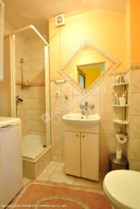ein Bad mit einem Waschbecken, einer Dusche und einem WC in der Unterkunft Pokoje u Gabi in Bytów