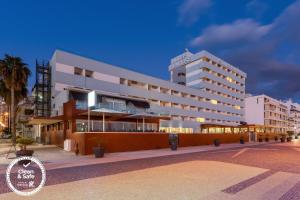 a large white building on a street at night at Dom Jose Beach Hotel (Plus) in Quarteira