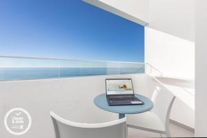 a laptop computer sitting on a table in a balcony at Dom Jose Beach Hotel (Plus) in Quarteira