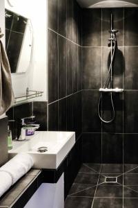 a bathroom with a sink and a shower at La Femme d'à Côté in Saint-Valéry-sur-Somme