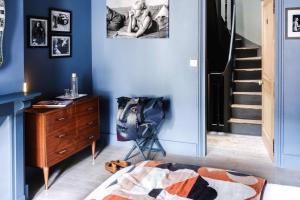 a bedroom with blue walls and a dresser and a chair at La Femme d'à Côté in Saint-Valéry-sur-Somme