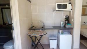 a small kitchen with a sink and a microwave at Hôtel - Gîte de Pressins in Pressins