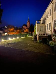 un bâtiment avec des lumières sur son côté la nuit dans l'établissement Schloss Hainfeld, à Hainfeld