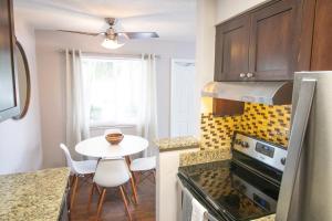 a kitchen with a table and a small table and chairs at The Victor Apartments By Lowkl in Fort Lauderdale