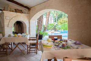 an outdoor dining room with tables and an archway at Masseria La Brunetta in Massafra