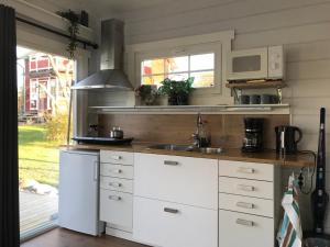 a kitchen with white cabinets and a sink at Lottas stuga in Smedjebacken