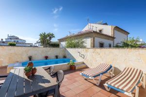 a patio with a table and chairs and a pool at Chalet adosado Atalaya P in Conil de la Frontera