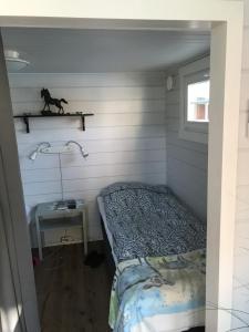 a small bedroom with a bed and a table at Lottas stuga in Smedjebacken