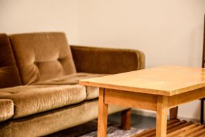 a couch and a table in a room at Tehtaan Hotelli in Karkkila