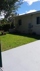 een huis met een grasveld en een oprit bij LUXURY Guayabita's House in Miami