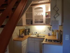 una pequeña cocina con armarios blancos y fregadero en Ferienwohnung Jebeweg App. 9 en Nordstrand