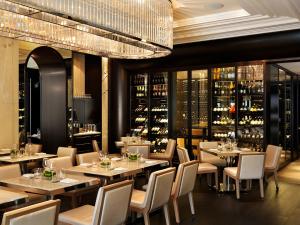 a restaurant with tables and chairs and a wine cellar at Rosewood Hotel Georgia in Vancouver
