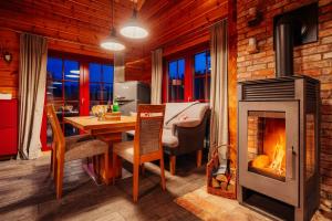 a living room with a fireplace and a dining table at Blockhaus an der Skiwiese Braunlage in Braunlage