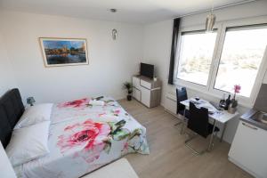 Schlafzimmer mit einem Bett und einem Schreibtisch mit einem Computer in der Unterkunft Studio apartman Moonlight in Zadar