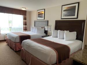 ein Hotelzimmer mit 2 Betten und einem Fenster in der Unterkunft Ramada by Wyndham Creston in Creston