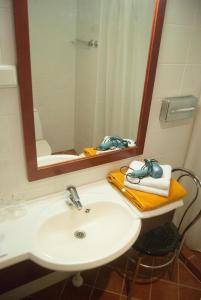 La salle de bains est pourvue d'un lavabo et d'un miroir. dans l'établissement Draakon Hotel, à Tartu