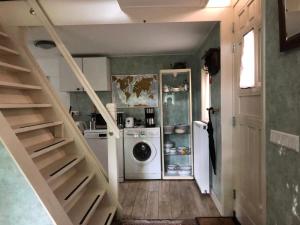 a laundry room with a washing machine and a staircase at Cozy Cottage in Utrecht