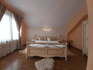a bedroom with a large white bed with a window at Vila Piscul Ursului in Predeal