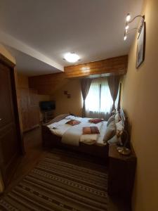 a bedroom with a large bed with a window at Vila Piscul Ursului in Predeal