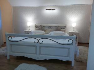 a bedroom with a white bed with two night stands at Vila Piscul Ursului in Predeal
