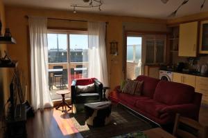 un soggiorno con divano rosso e finestra di Lavra Sea & Sun Beach Apartment (up to 4 guests) a Lavra