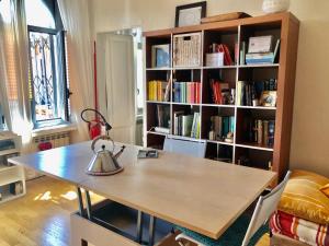 a room with a table and a book shelf with books at La Casa sul Ballatoio - Isola Milano in Milan