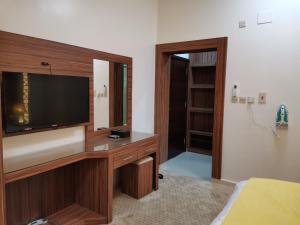 a living room with a television and a bedroom at سكون للشقق الفندقية in Najran