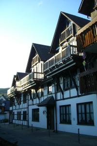 ein großes weißes Gebäude mit Balkon darüber in der Unterkunft Apartment Central in Willingen